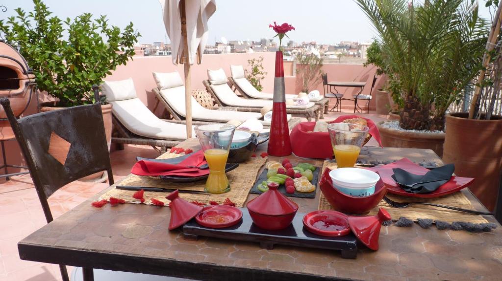 une table avec de la nourriture et des boissons sur une terrasse dans l'établissement Dar Andamaure, à Marrakech