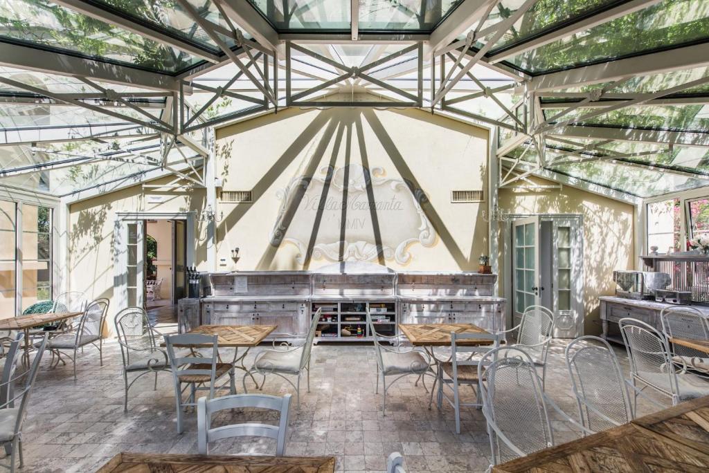 une salle avec des tables, des chaises et une scène dans l'établissement Villa Mazzanta Relais & Hotel, à Vada