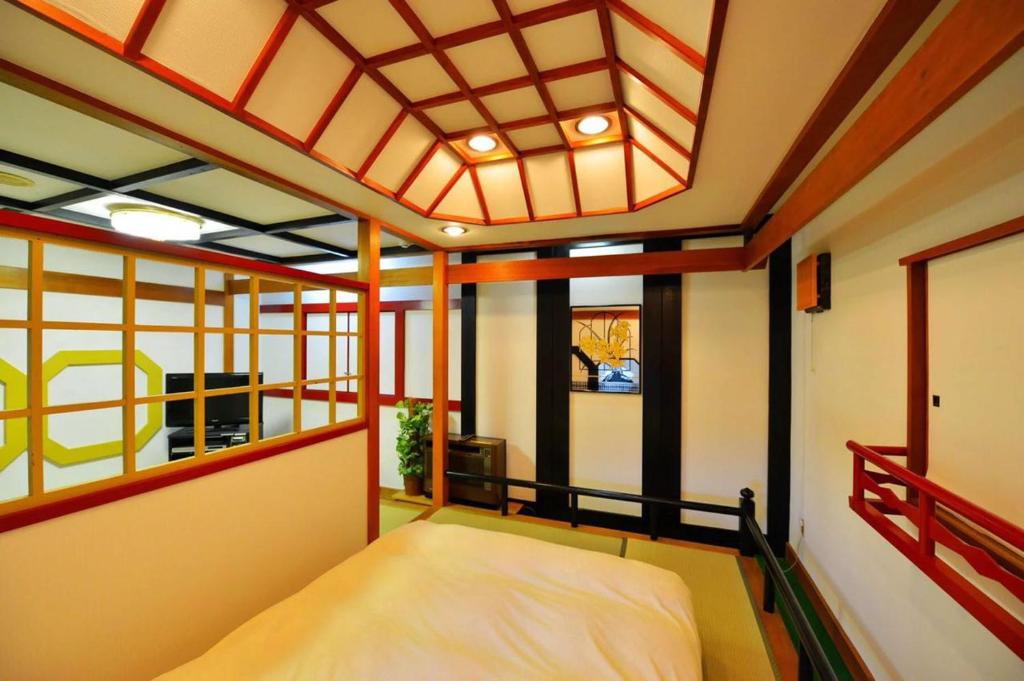 une chambre avec un lit dans une pièce avec des fenêtres dans l'établissement Hotel Otani, à Chiba