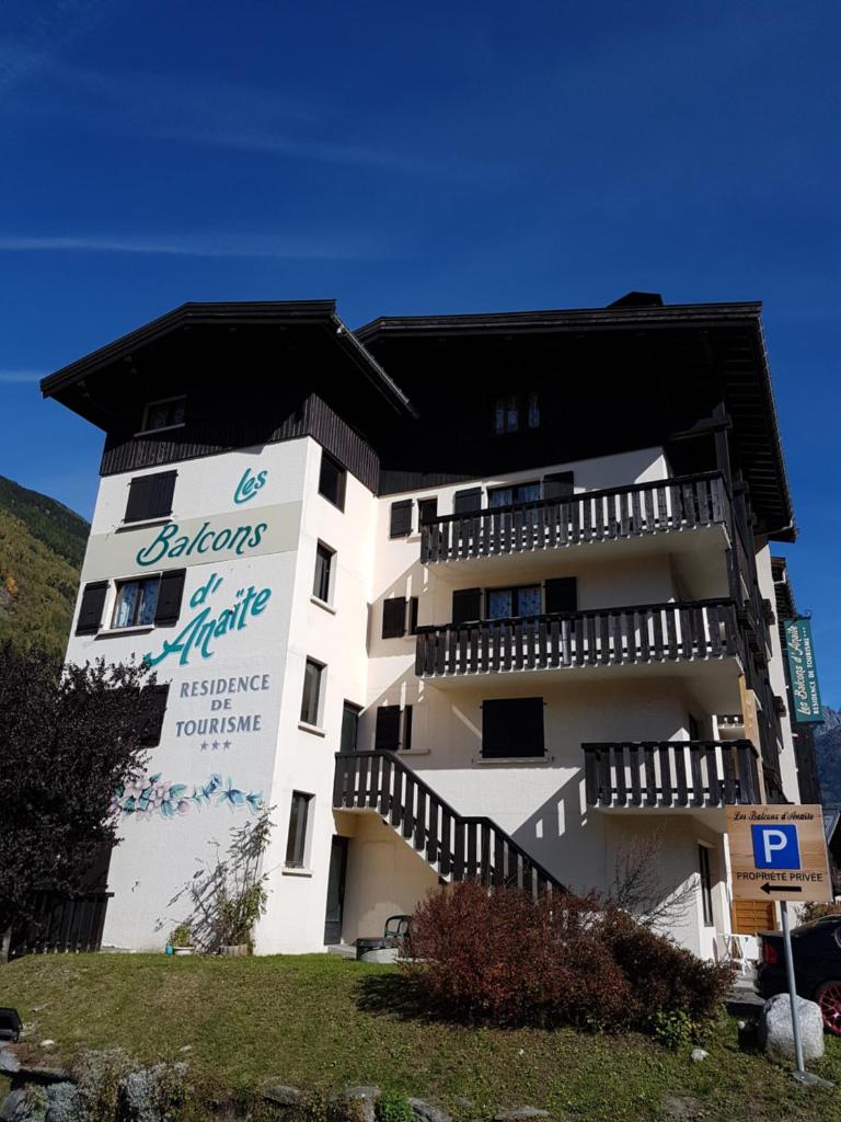 un bâtiment blanc avec un panneau sur le côté dans l'établissement Studio d'Anaite, aux Houches
