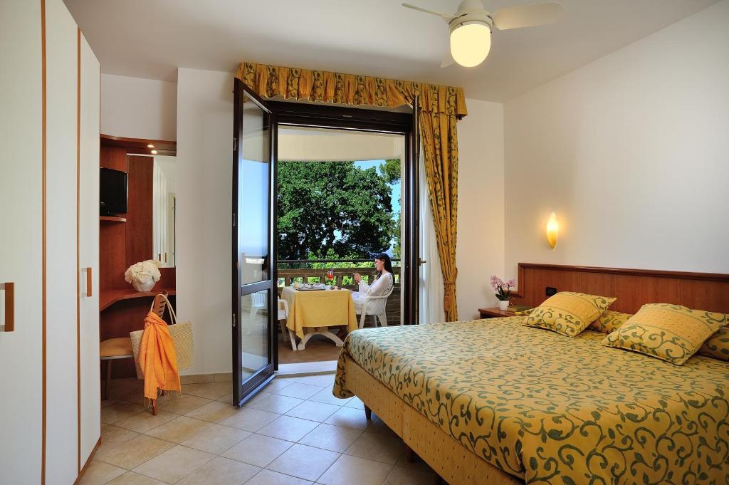 une chambre avec un lit et une porte donnant sur un balcon dans l'établissement Hotel Bel Sit, à Senigallia