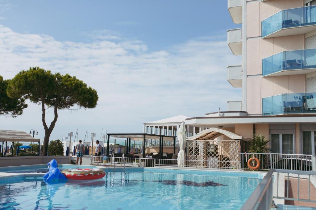 une grande piscine à côté d'un immeuble dans l'établissement Hotel La Bussola, à Lido di Jesolo
