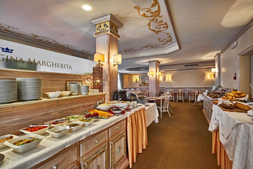 - un restaurant avec plusieurs tables et des plats dans l'établissement Residence Columbia, à Bibione