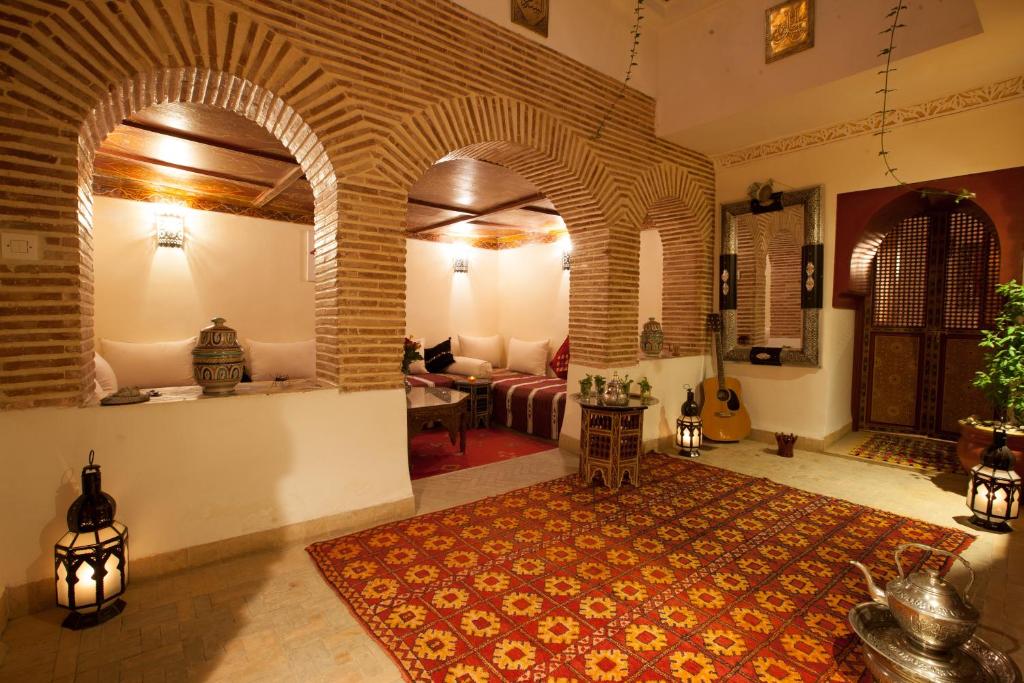 - un salon avec un canapé et une chambre dotée d'un tapis dans l'établissement Riad Hna Ben Saleh, à Marrakech