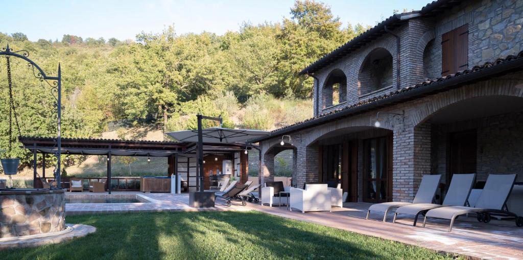 - une terrasse avec des chaises blanches dans un bâtiment dans l'établissement Villa valtopina, à Valtopina