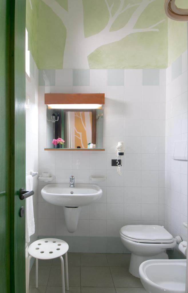 une salle de bain avec un lavabo, des toilettes et un miroir dans l'établissement Grand Hotel Mediterraneo, à Santa Cesarea Terme