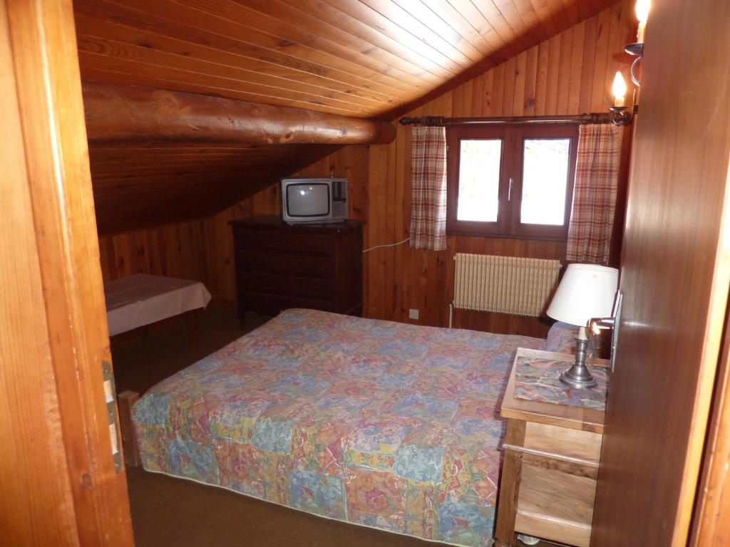 - une chambre avec un lit et une télévision dans une cabine dans l'établissement Chalet Le Starfu, à Crest-Voland
