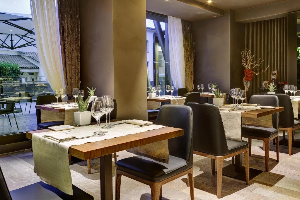 une salle à manger avec des tables, des chaises et des verres à vin dans l'établissement Grand Hotel Campione, à Campione dʼItalia