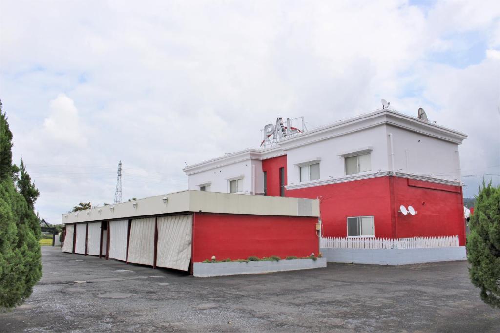 un bâtiment rouge et blanc avec un garage dans l'établissement Pal Annex Ogawa, à Kumamoto