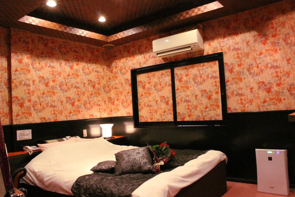 - une chambre avec un lit et une fenêtre ornée de papier peint floral dans l'établissement Pal Annex Ogawa, à Kumamoto