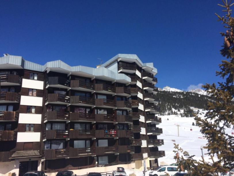 un grand immeuble avec de la neige au sol dans l'établissement La Chamoisiere Montgenevre, à Montgenèvre