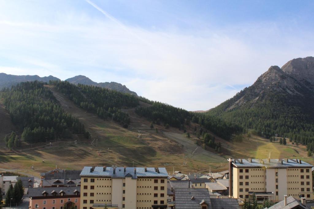 un groupe de bâtiments devant une montagne dans l'établissement La Chamoisiere Montgenevre, à Montgenèvre 13 autres photos