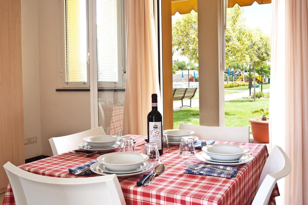 - une table avec une bouteille de vin et une table avec des chaises dans l'établissement Residence Borgomare, à Albenga
