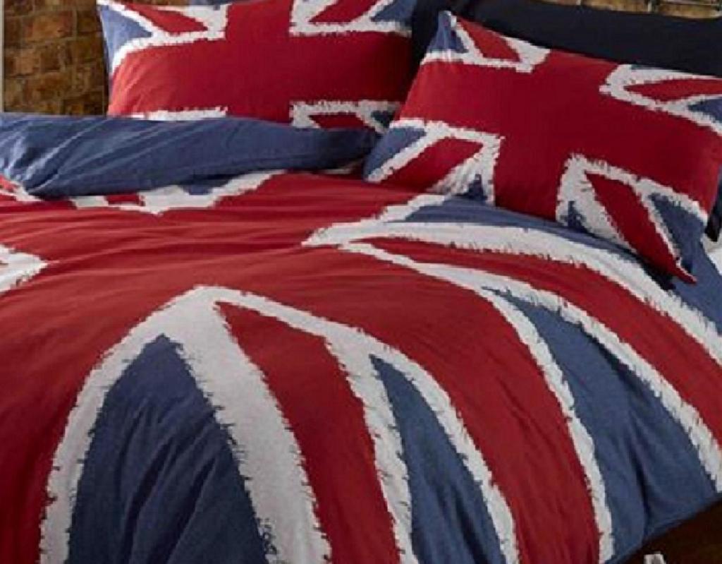 - un lit avec une couverture et des oreillers rouges et bleus dans l'établissement Plagne AIME 2000 Ski Apartments, à Aime La Plagne