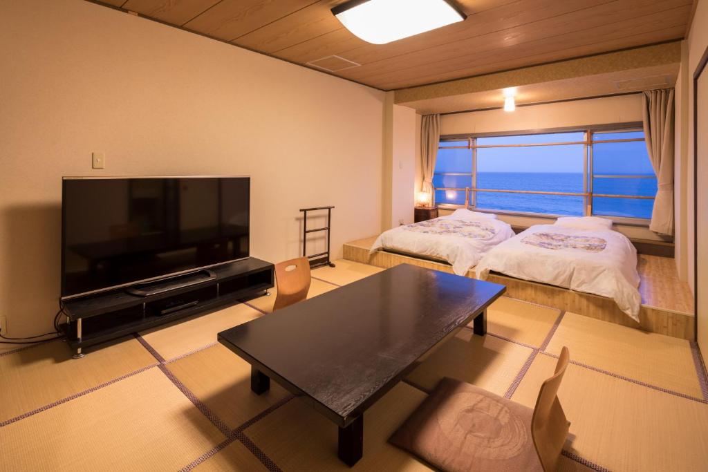 un salon avec deux lits et une télévision à écran plat dans l'établissement Inubosaki Kanko Hotel, à Choshi