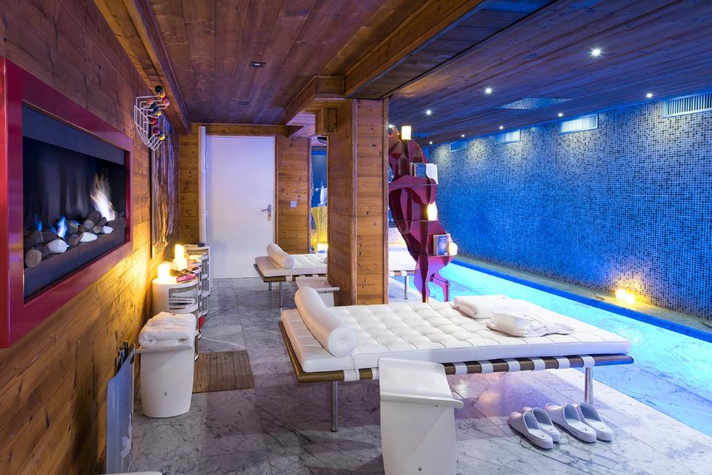 - un salon avec un canapé et une piscine dans l'établissement Snow Lodge Hotel Courchevel 1850, à Courchevel