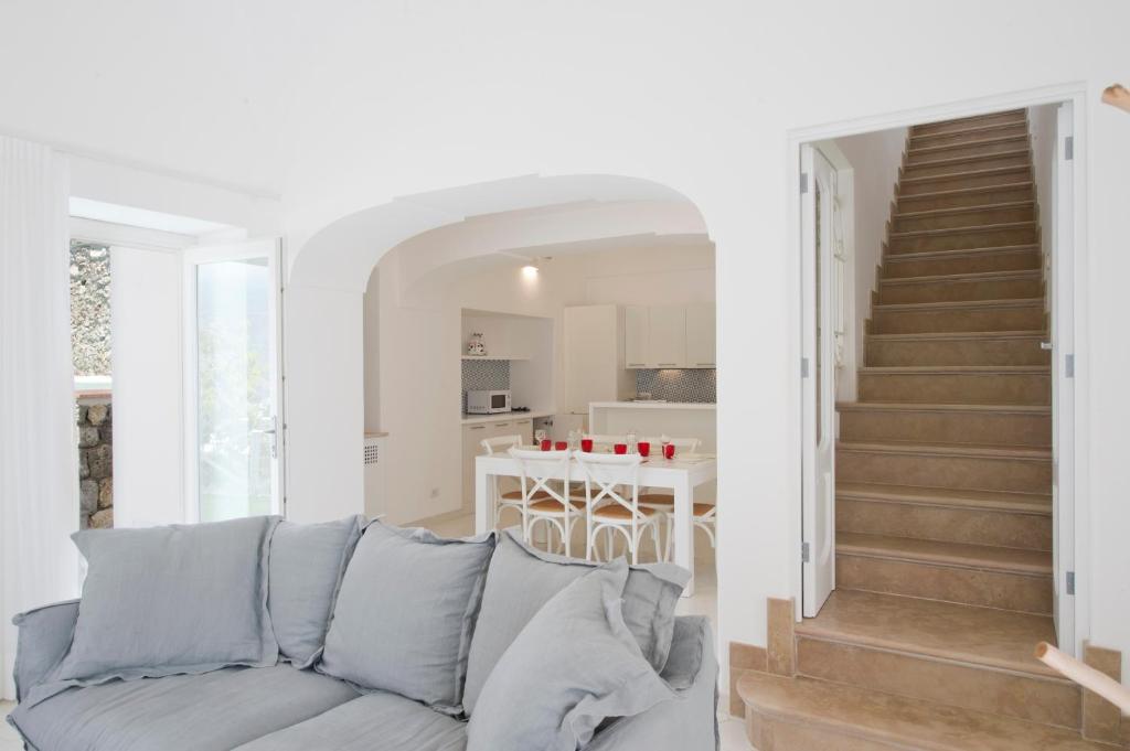 un salon avec un canapé et une cuisine dans l'établissement Villa Imperati, à Praiano