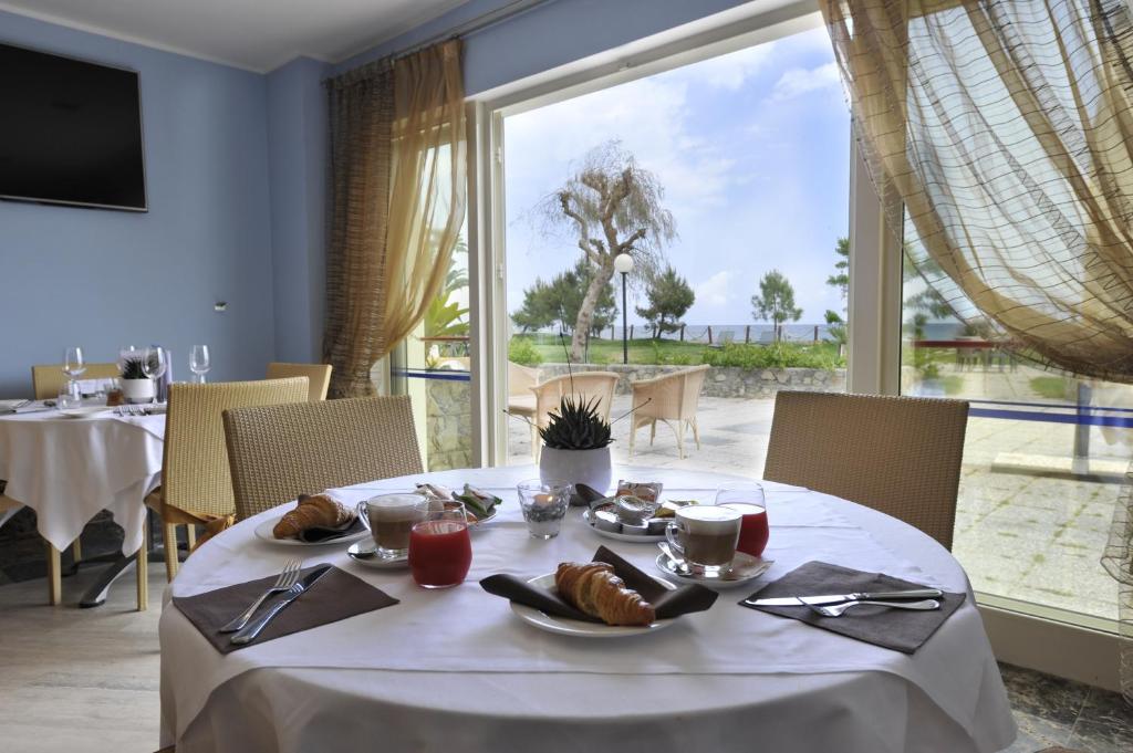 - une table avec de la nourriture et une grande fenêtre dans l'établissement Aregai Marina Hotel & Residence, à Santo Stefano al Mare