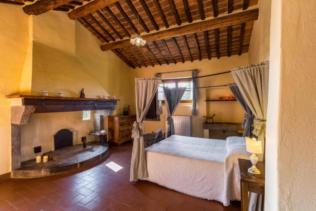une chambre avec un lit et une cheminée dans l'établissement Villa Fontocchio, à Cortone