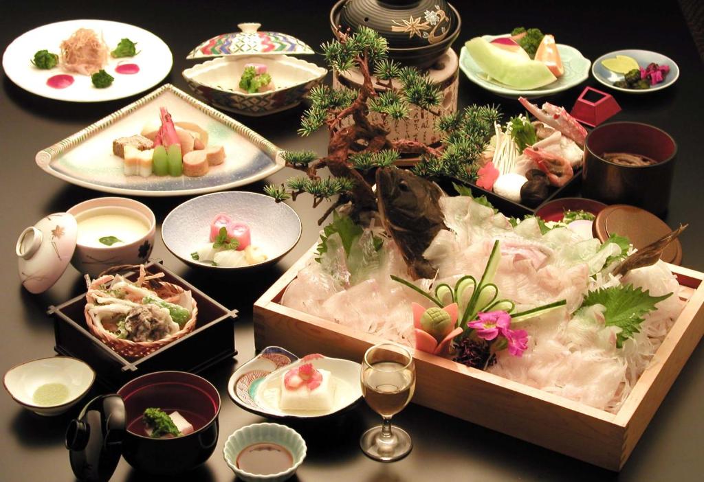 une table avec des assiettes de nourriture sur une table dans l'établissement Unzen Sky Hotel, à Unzen
