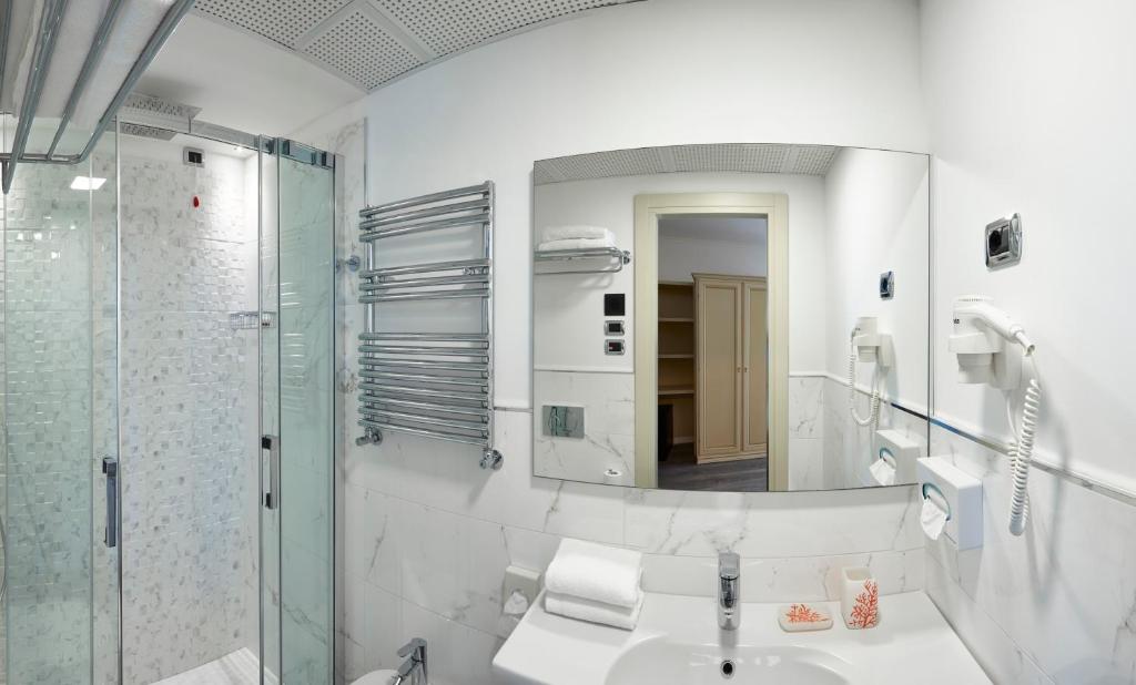 une salle de bain avec un lavabo et un miroir dans l'établissement Termini Beach Hotel & Suites, à Lido di Jesolo