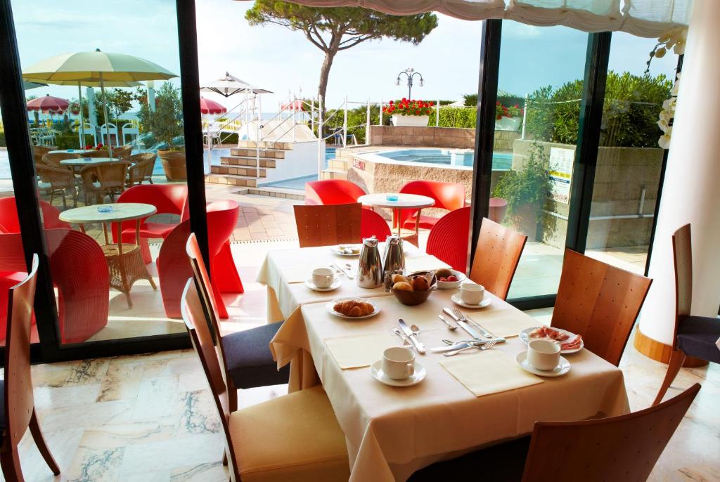 - une table dans un restaurant avec vue sur la piscine dans l'établissement Ruhl Beach Hotel & Suites, à Lido di Jesolo