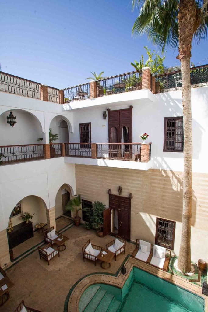 une maison avec une piscine et un palmier dans l'établissement Riad Amira, à Marrakech