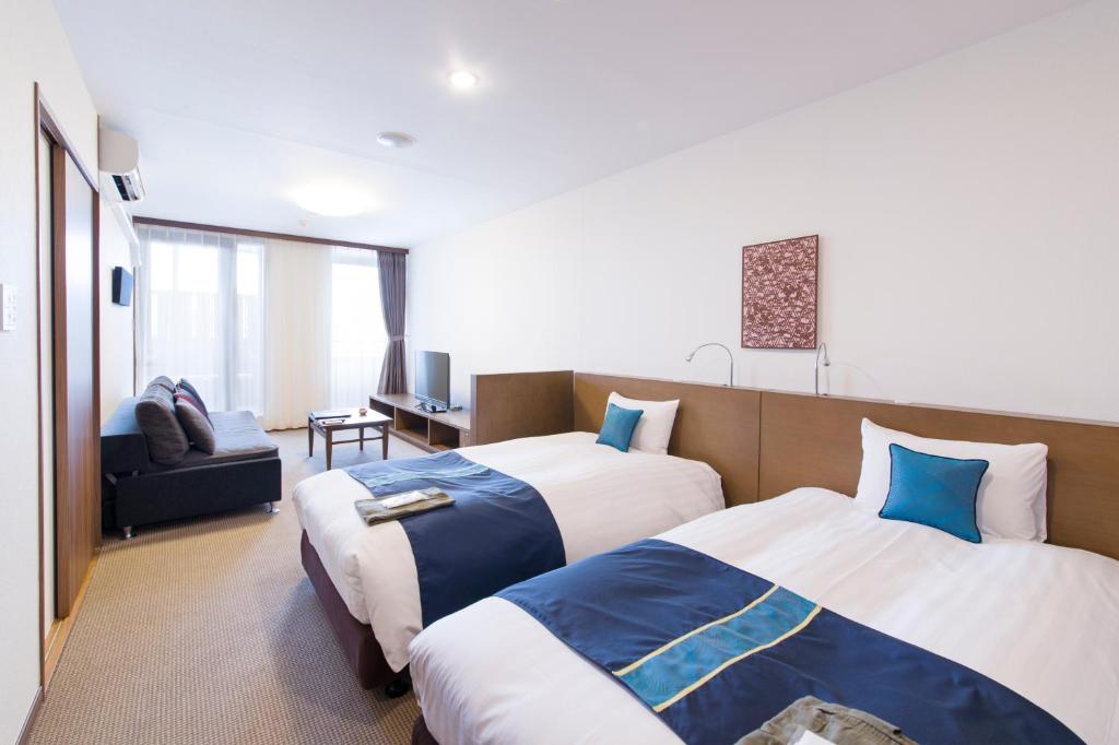 une chambre d'hôtel avec deux lits et un canapé dans l'établissement Isegekusando Iseshinsen, à Ise