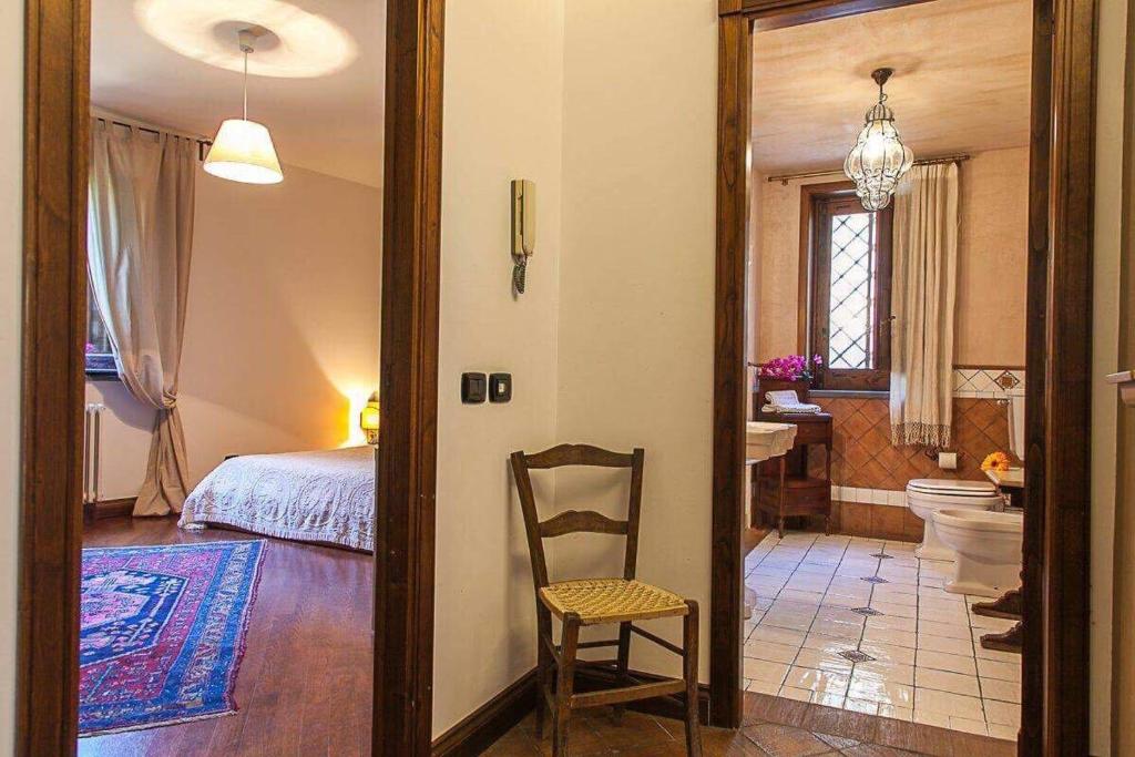 - une chambre avec un lit et une chaise ainsi qu'une salle de bains dans l'établissement Casa Dimora Vittoria, à Catane