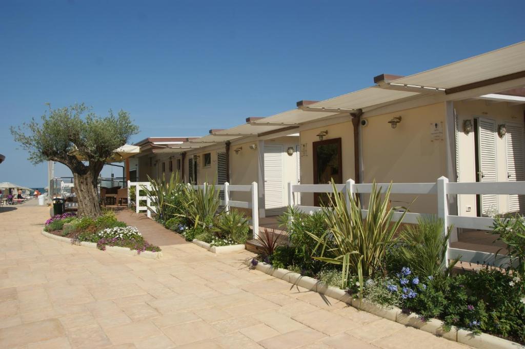 une rangée de mobile homes avec une clôture blanche dans l'établissement Hotel Bamby, à Cervia 9 autres photos