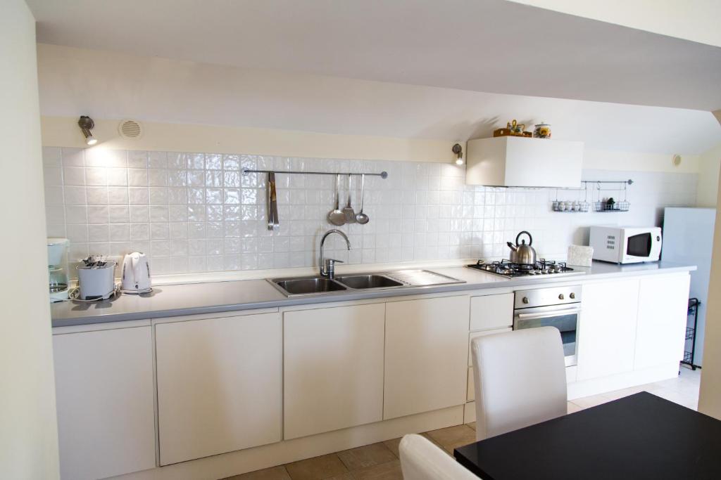 une cuisine avec des armoires blanches et un évier dans l'établissement Villa Knight, à Amalfi