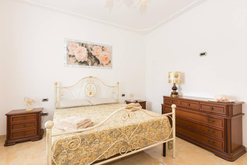 - une chambre avec un lit et deux commodes dans l'établissement Villa Abbracciavento, à Martina Franca