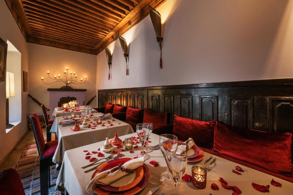 une salle à manger avec deux tables et des sièges rouges dans l'établissement Riad Azzar, à Marrakech 37 autres photos