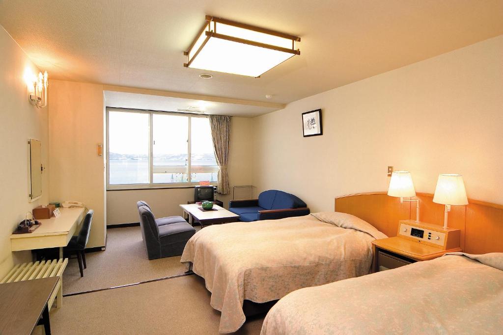 une chambre d'hôtel avec deux lits et un bureau dans l'établissement Hotel Grand Toya, à Lac Tōya