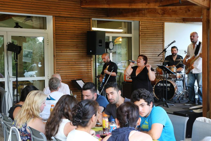 un groupe de personnes assises dans un restaurant avec un groupe dans l'établissement Camping le Nid du Parc, à Villars-les-Dombes 37 autres photos