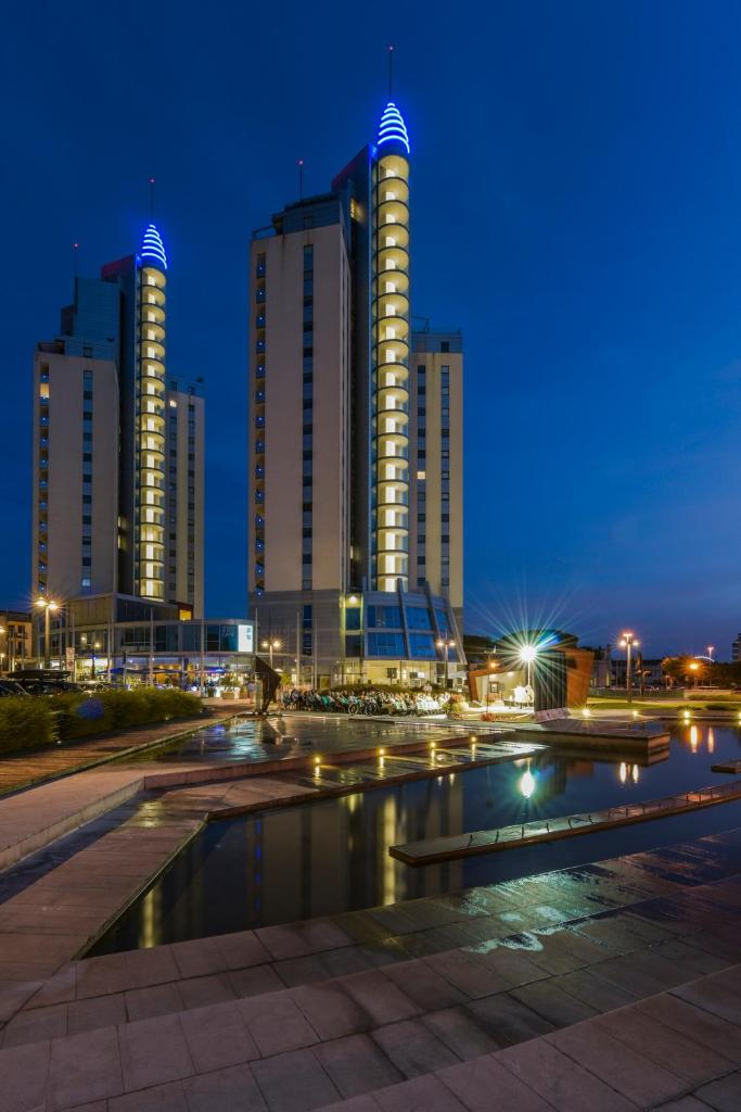 un horizon de ville la nuit avec de grands immeubles dans l'établissement Albergo Ridente, à Lido di Jesolo