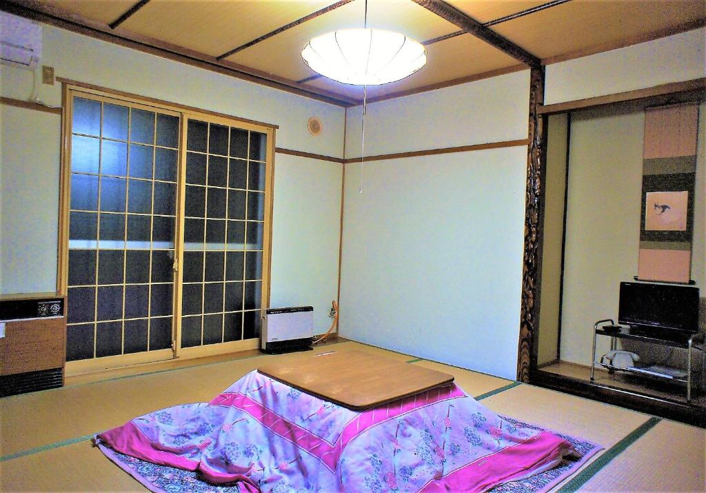 une pièce vide avec une grande fenêtre et une table dans l'établissement Yonagoya, à Kami