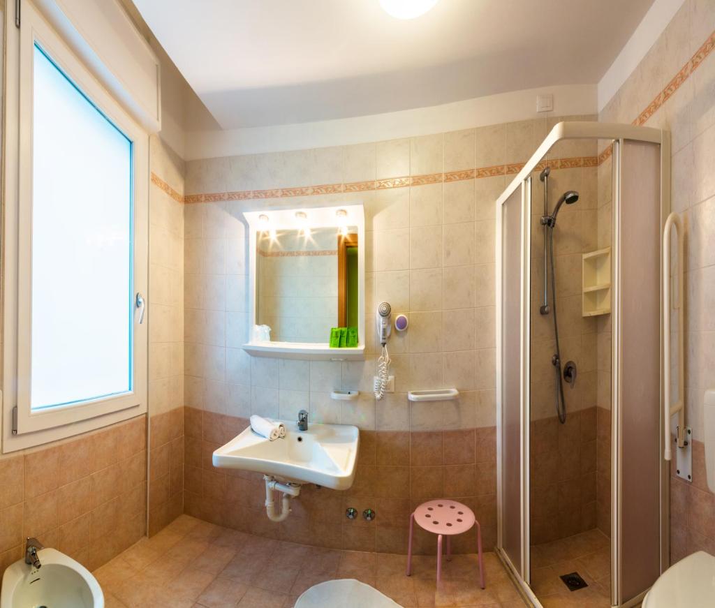 une salle de bain avec un lavabo et une douche dans l'établissement Hotel Milano 3S, à Bibione 19 autres photos