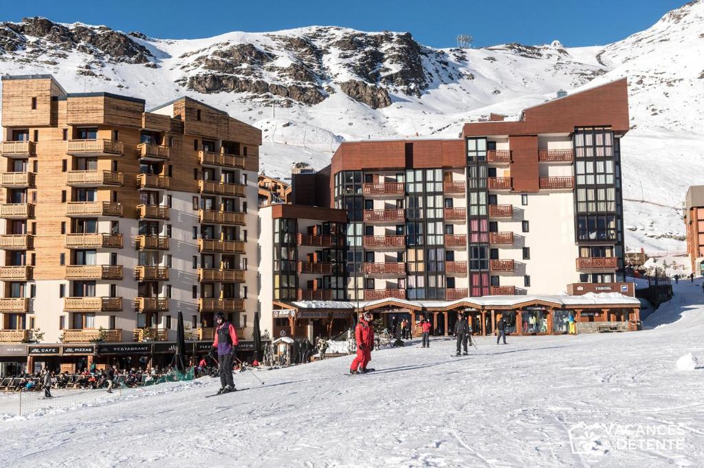 Des personnes à skis dans la neige devant un hôtel dans l'établissement Nazca J2, à Val Thorens
