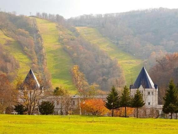 une église dans un champ avec une colline en arrière-plan dans l'établissement Kurplaza Pirika, à Hanaishi