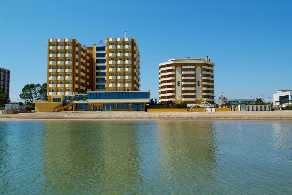 deux grands bâtiments à côté d'une masse d'eau dans l'établissement Grand Eurhotel, à Montesilvano