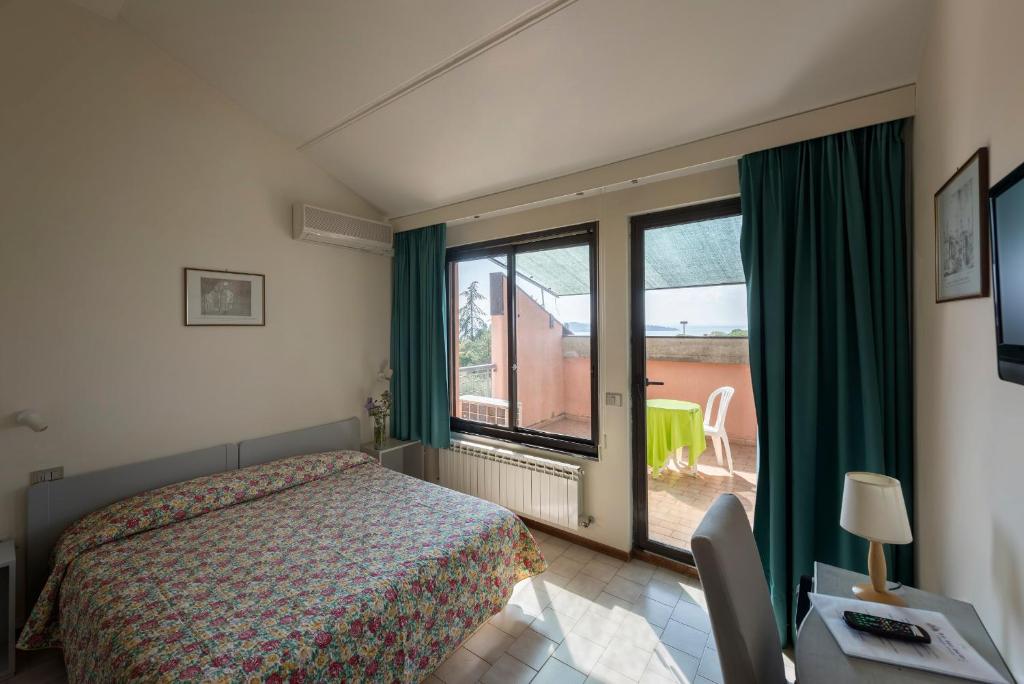 une chambre avec un lit et une grande fenêtre dans l'établissement Hotel Le Tre Isole, à Magione