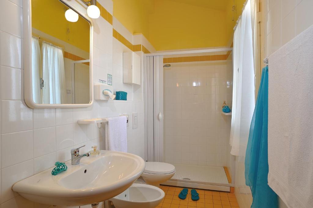 une salle de bain blanche avec un lavabo et des toilettes dans l'établissement Hotel Capri, à Rimini