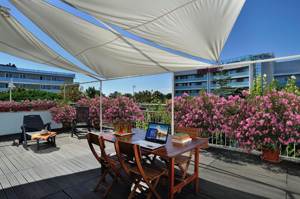 d'une terrasse avec une table et un ordinateur portable. dans l'établissement Hotel Capri, à Rimini