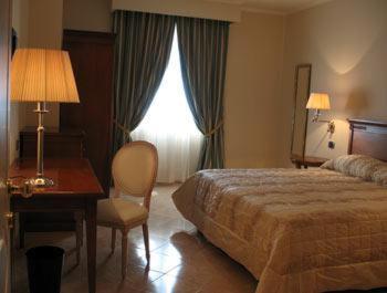 une chambre d'hôtel avec un lit, un bureau et une fenêtre dans l'établissement Hotel San Giorgio, à Crotone