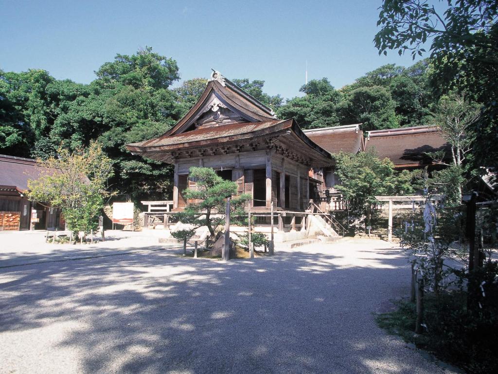 un bâtiment avec un toit et un arbre devant lui dans l'établissement Hotel Wellness Notoji, à Hakui