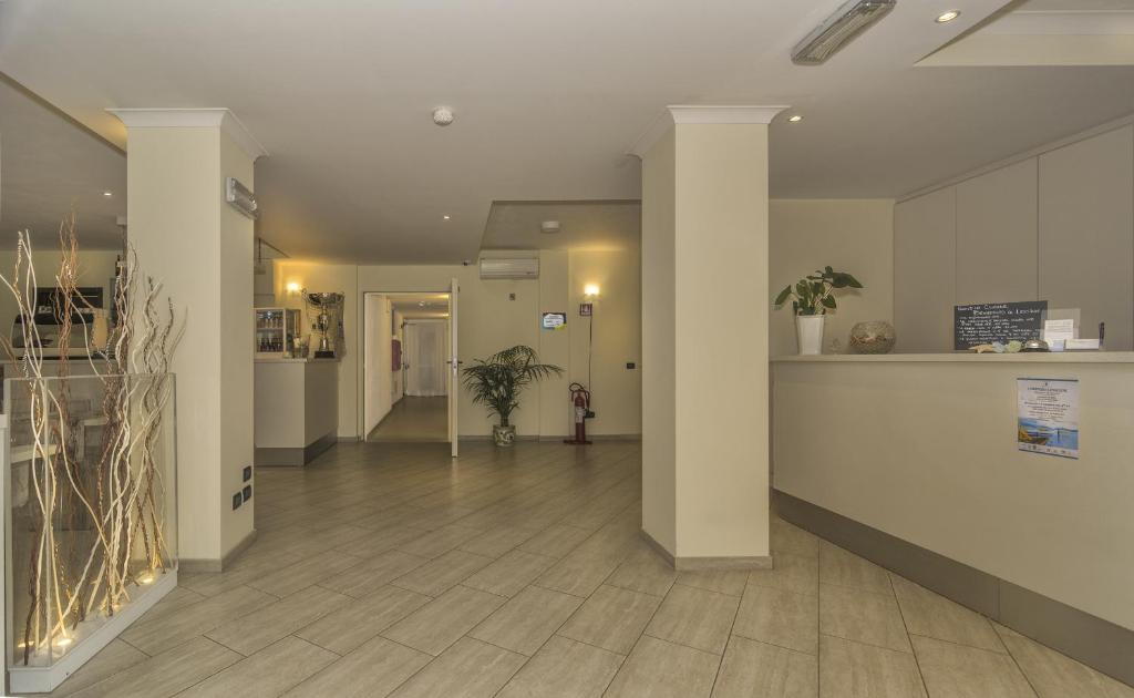 un couloir d'un bâtiment avec des colonnes et un hall d'entrée dans l'établissement Hotel Lido Inn, à Lido di Camaiore