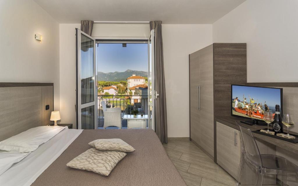 une chambre avec un lit et une télévision à écran plat dans l'établissement Hotel Lido Inn, à Lido di Camaiore