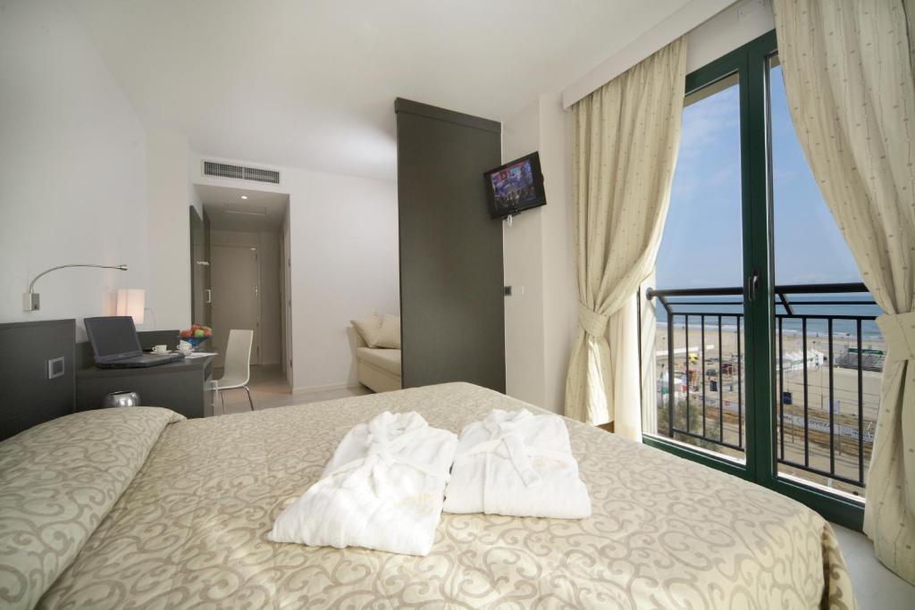 une chambre d'hôtel avec un lit avec des serviettes dessus dans l'établissement Hotel Dante Family Spa Resort, à Cervia