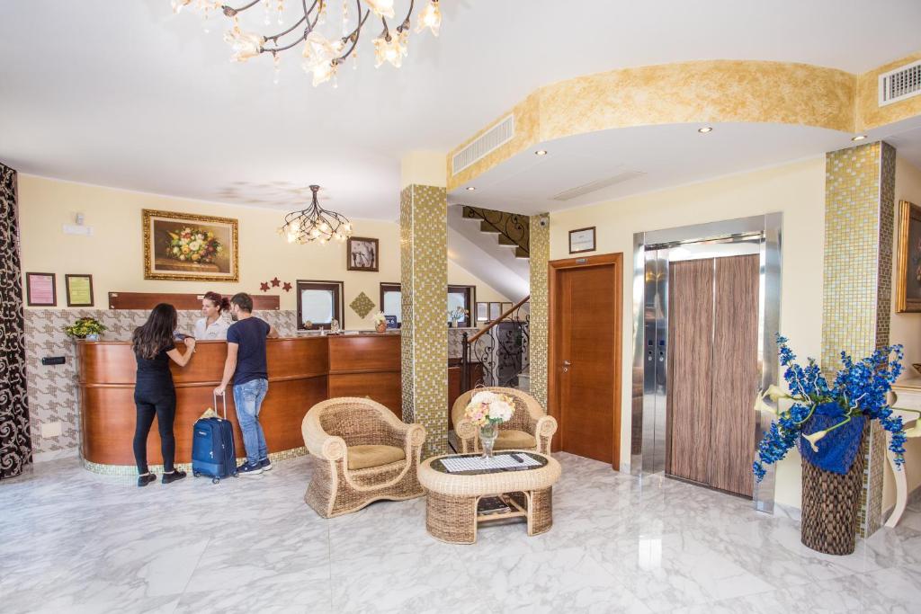 2 personnes debout au bar dans le hall de l'hôtel dans l'établissement Hotel Salento Mirfran, à Torre San Giovanni